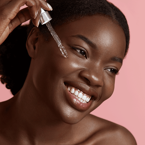 Woman applying facial oil with dropper